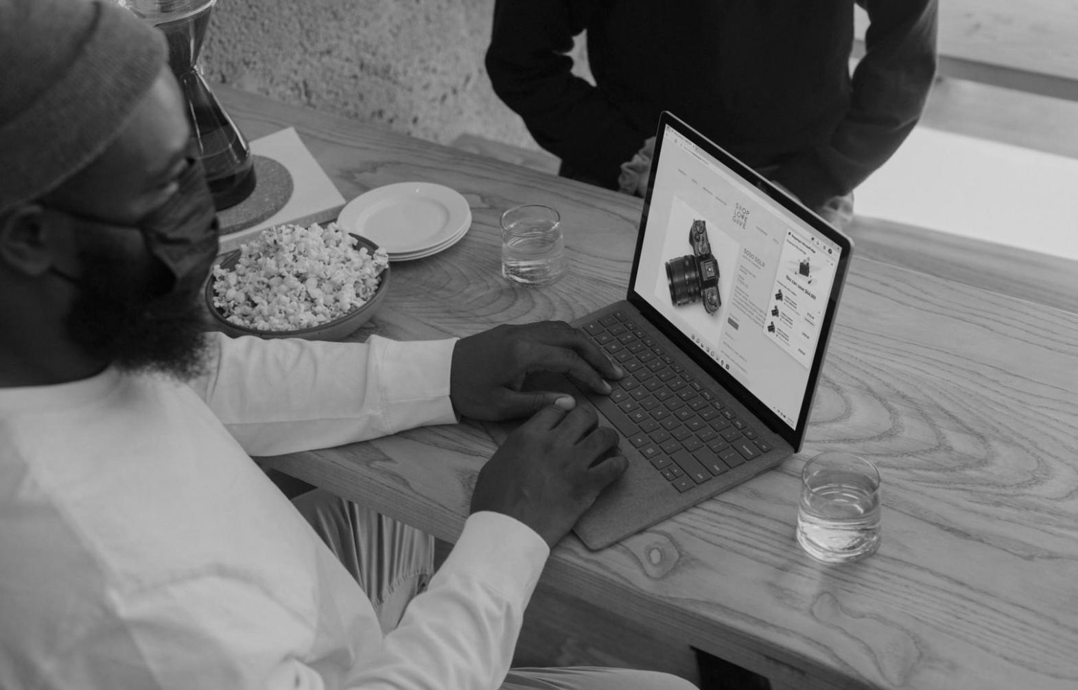 Students collaborating on financial analysis project using laptops and printed reports